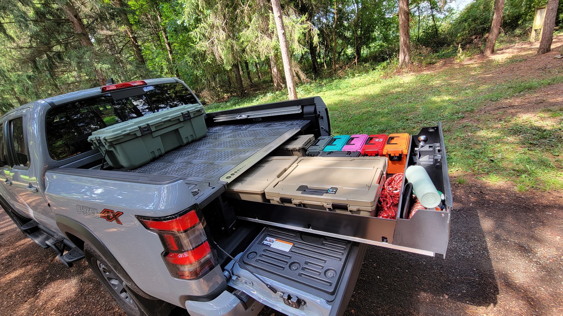 Figure 2 — The 177 lb this volume keeps proposing to delete, and what it buys: a full-width drawer that runs out past the tailgate under a weatherproof deck that stays usable with the drawer open. …